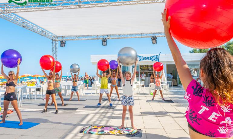 Outdoor-Fitnesskurs mit Gymnastikbällen am Strand.