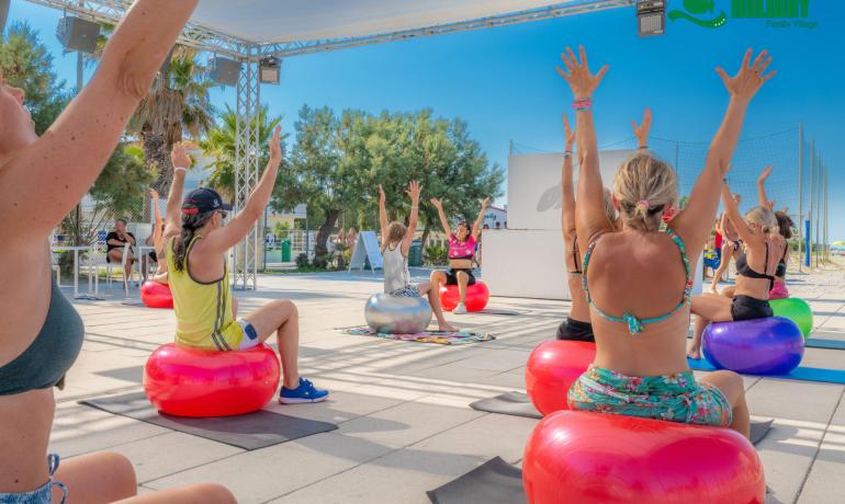 Outdoor fitness class with colorful balls and enthusiastic participants.