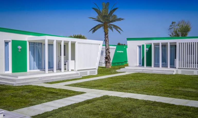 Moderne Ferienhäuser mit Palmen und Garten.