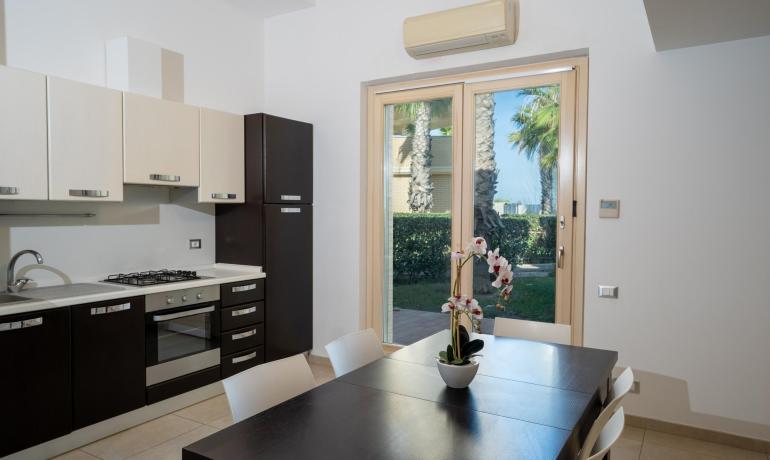 Cuisine moderne avec table à manger et vue sur le jardin.